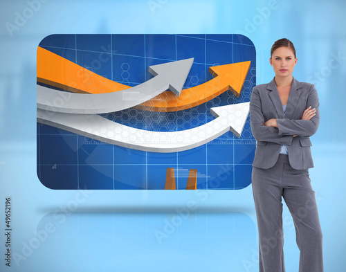 Photo: Businesswoman crossed arms near to a digital screen Businesswoman crossed arms near to a digital screen