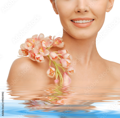 Photo: lovely woman with orchid flower lovely woman with orchid flower