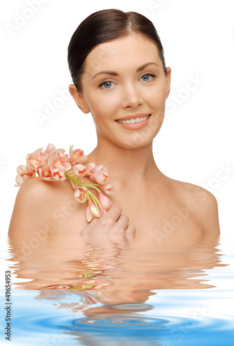 Photo: lovely woman with orchid flower lovely woman with orchid flower