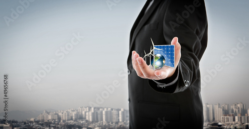 Photo: Business man hold Alternative Energy (solar cell, earth, wind tu Business man hold Alternative Energy (solar cell, earth, wind tu
