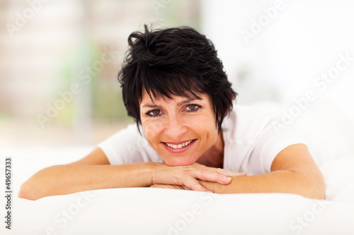 Photo: pretty mid aged woman lying on bed at home pretty mid aged woman lying on bed at home