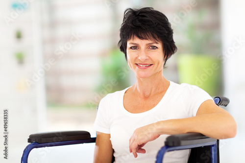 Photo: optimistic handicapped middle aged woman sitting on wheelchair optimistic handicapped middle aged woman sitting on wheelchair