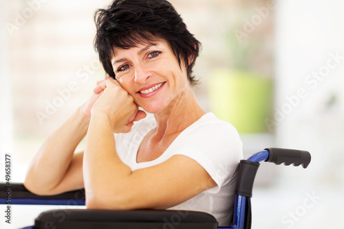 Photo: happy disabled middle aged woman sitting on wheelchair happy disabled middle aged woman sitting on wheelchair