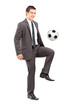 Full length portrait of a young handsome businessman kicking a f