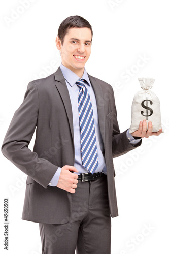Photo: Happy young businessman holding a bag with US dollar sign Happy young businessman holding a bag with US dollar sign