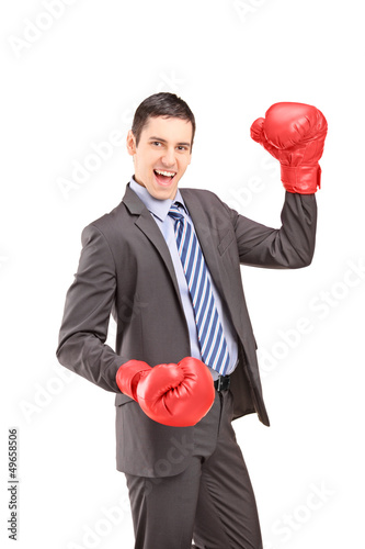 Photo: Happy young businessman with red boxing gloves Happy young businessman with red boxing gloves