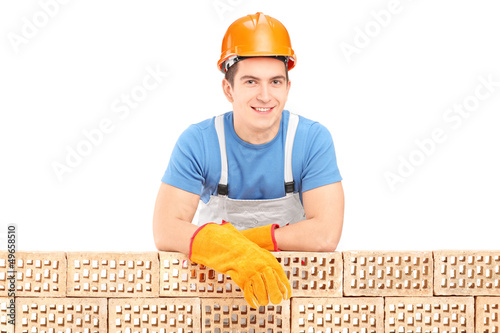 Photo: Male construction worker resting on a brick wall Male construction worker resting on a brick wall