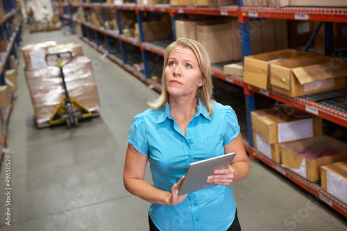 Photo: Businesswoman Using Digital Tablet In Distribution Warehouse Businesswoman Using Digital Tablet In Distribution Warehouse