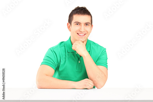Photo: Young smiling man sitting Young smiling man sitting