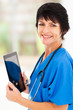 Photo: pretty middle aged medical doctor with tablet computer in office pretty middle aged medical doctor with tablet computer in office