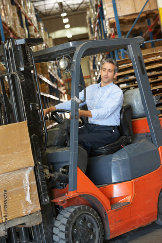 Photo: Man Driving Fork Lift Truck In Warehouse Man Driving Fork Lift Truck In Warehouse