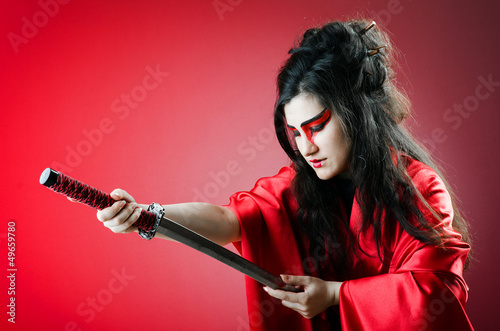Photo: Female sword warriod in dark studio Female sword warriod in dark studio