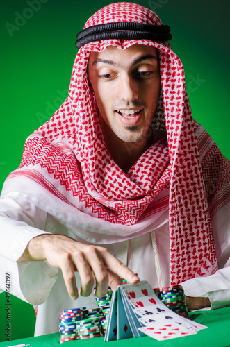 Photo: Arab playing in casino - gambling concept with man Arab playing in casino - gambling concept with man