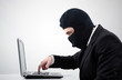 Hacker stealing information from a computer at the desk