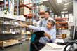 Photo: Business Colleagues Working At Desk In Warehouse Business Colleagues Working At Desk In Warehouse