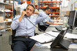 Photo: Businessman Working At Desk In Warehouse Businessman Working At Desk In Warehouse