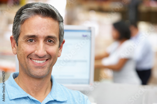 Photo: Man At Computer Terminal In Distribution Warehouse Man At Computer Terminal In Distribution Warehouse
