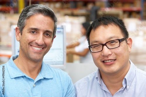 Photo: Two Men At Computer Terminal In Distribution Warehouse Two Men At Computer Terminal In Distribution Warehouse