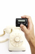 Old landline telephone and human hand holding pager