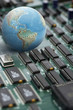 Globe on green circuit board, close up