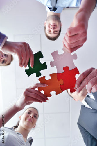 Photo: Group of business people assembling jigsaw puzzle Group of business people assembling jigsaw puzzle