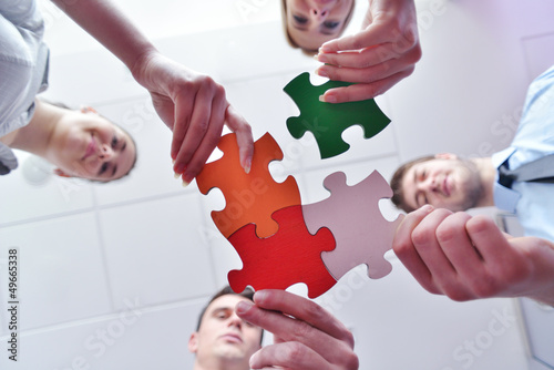 Photo: Group of business people assembling jigsaw puzzle Group of business people assembling jigsaw puzzle