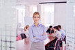 business woman with her staff in background at office
