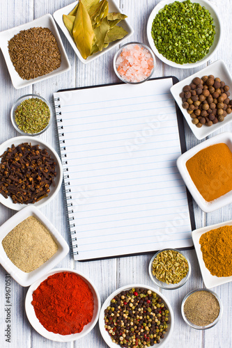 Photo: Cookbook and various spices and herbs. Cookbook and various spices and herbs.