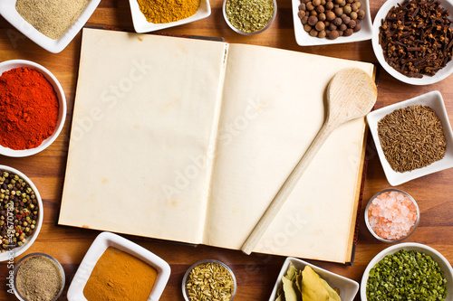 Photo: Cookbook and various spices and herbs. Cookbook and various spices and herbs.