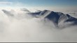 Big mountain over clouds form in a valley - time lapse video