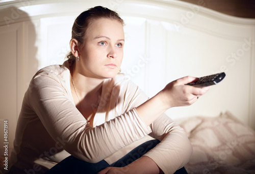 Photo: Young woman is watching tv. Young woman is watching tv.