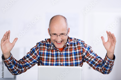 Photo: mann schaut auf laptop und jubelt mann schaut auf laptop und jubelt