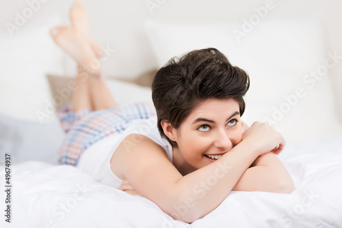 Photo: lachende frau auf dem bett schaut nach oben lachende frau auf dem bett schaut nach oben