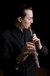 professional flutist musician playing flute on black background