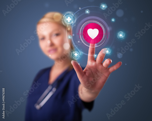 Photo: Young nurse pressing modern medical type of buttons Young nurse pressing modern medical type of buttons