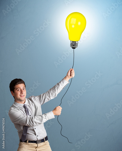 Photo: Handsome man holding light bulb balloon Handsome man holding light bulb balloon