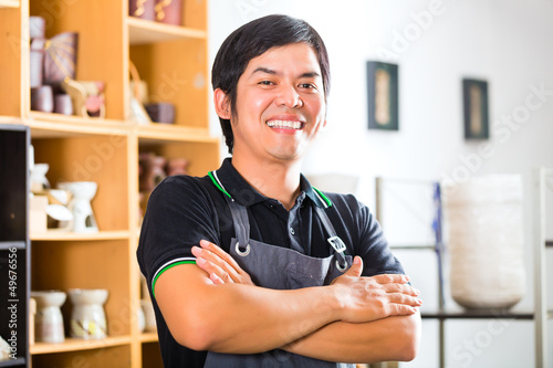 Photo: Asian Potter in his shop selling souveniers Asian Potter in his shop selling souveniers