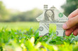 Foto: Hand holding banknote house icon,real estate concept. Hand holding banknote house icon,real estate concept.