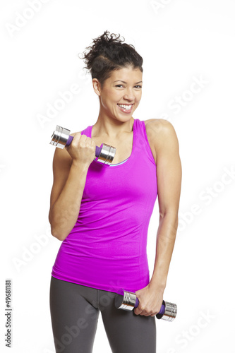 Photo: Young woman exercising holding dumbbells Young woman exercising holding dumbbells