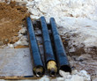 Three black pipes on the snow