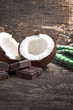 Coconut with chocolate on old wooden background