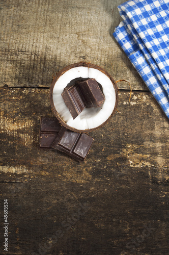 Photo: Coconut with chocolate on old wooden background Coconut with chocolate on old wooden background