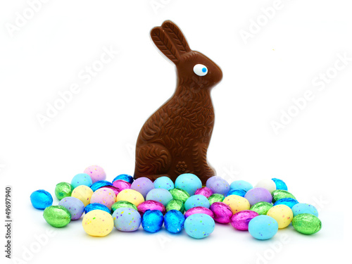 Photo: Chocolate Easter bunny with pile of colorful eggs Chocolate Easter bunny with pile of colorful eggs