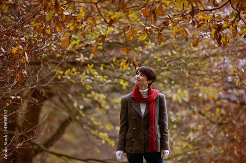 Photo: A woman walking through the countryside in autumn time A woman walking through the countryside in autumn time