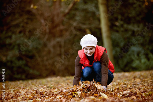 Photo: A woman gathering autumn leaves A woman gathering autumn leaves