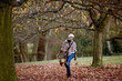 A woman kicking leaves in autumn time