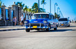 Fahrender Oldtimer auf der Promenade in Kavanna Kuba
