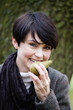 A woman eating a pear in autumn time