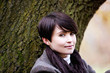 A woman sitting beneath a tree in autumn time, close up