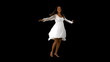 Girl in white dress twirling on black background